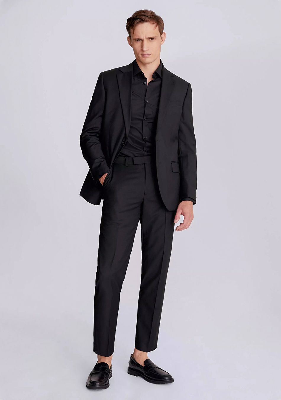 Black suit, black dress shirt, and black loafers