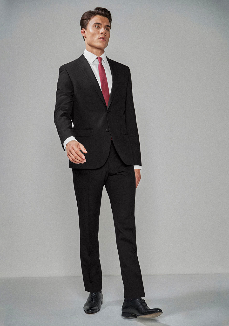 Black suit, white dress shirt, red tie, and black derby dress shoes